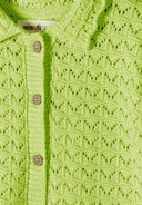 Close-up of light green knit fabric with a delicate pointelle design and wooden buttons for kids fashion.