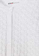 Close-up of white girls cardigan with textured geometric pattern and button-up front design.