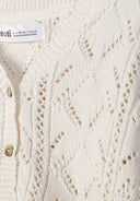 Detail of a white cotton cardigan for girls, featuring a button front and pointelle knit.