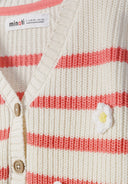 Detail of girls' knitted cardigan with coral and white stripes, featuring daisy embroidery and button closure.