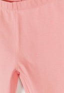 Close-up of soft pastel pink kids leggings with elasticated waistband showing fine stitching and smooth fabric design.