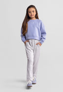 Young girl modeling a blue embroidered sweatshirt with chest detail and matching casual pants in kids fashion style