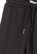 Close-up of black wide leg joggers with elasticated waist and drawstring, showcasing soft fabric texture and side pockets design.