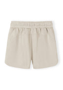 Beige women's shorts with elasticated waist, smooth fabric, and simple, comfortable design for casual wear.
