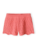 Coral pink crochet shorts for girls featuring a delicate knit pattern and scalloped hem, perfect for kids' fashion.