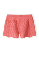Coral pink crochet shorts with ribbed waistband and intricate scalloped hem design for girls.