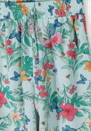 Close-up of mint fabric with colorful tropical floral and butterfly print design on kidswear.