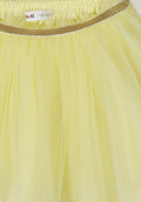 Light yellow girls tulle skirt with elastic waistband and gold glitter trim showcasing delicate design details.