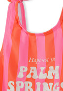 Close-up of pink and coral striped girls swimsuit with adjustable straps and bow detail, featuring playful text design.