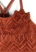 Close-up of breathable copper crochet fabric with adjustable straps and detailed bow design for kids fashion.