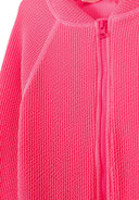 Close-up of textured solid pink fabric with front zipper design on girls long sleeve swimsuit