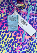 Close-up of colorful purple leopard print rash vest fabric featuring front zipper and protective UPF 50+ tag design.