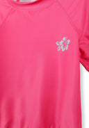 Pink girls rash top with subtle floral design detail and stylish stitching, ideal for kids' beachwear or swim activities.