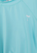 Light blue quick-dry girls rash top with short sleeves and a small white palm tree design near the neckline