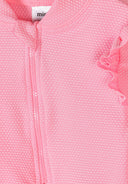 Close-up of textured light pink girls swimsuit fabric with zipper and ruffle detail design