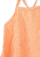 Close-up of neon orange kids swimsuit fabric with textured floral jacquard design and ruffle shoulder straps.