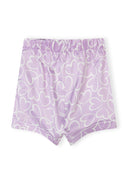 Lilac satin shorts with white heart print and elastic waistband, part of a girls' pajama set design.