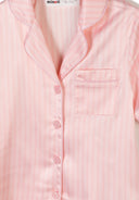 Close-up of a girls satin pyjama top with pink and white stripes and button front design