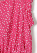 Close-up of pink fabric with small white floral print and ruffled short sleeve design for girls garment