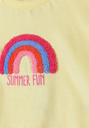 Close-up of a pale yellow cotton t-shirt with a textured rainbow applique and "SUMMER FUN" text design for kids.