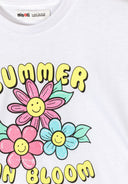 Close-up of a white cotton t-shirt with a colorful smiling flower design and playful yellow text summer bloom