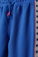 Girls jogpant with side taping blue 3-14y featuring soft fleece, elastic waistband, drawcord ties, and star patterned side taping.