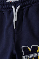 Boys fleece jogpant in navy blue with yellow stripes and 1997 logo